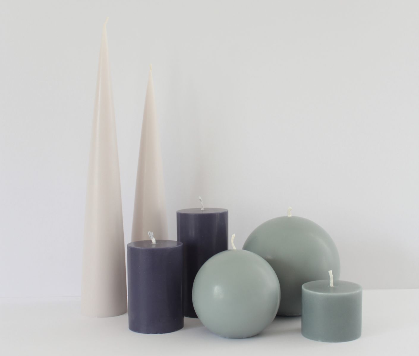 image of ball candle, pillar candles and cone shape candles in a cluster. 