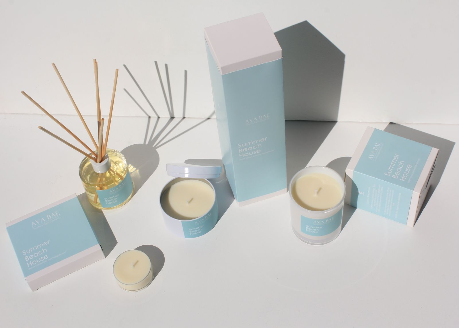 summer beach house home fragrance range with scented candles and reed diffuser in aqua blue
